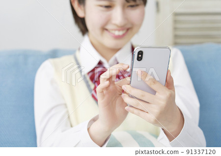 在客廳使用智能手機的高中女生特寫 91337120