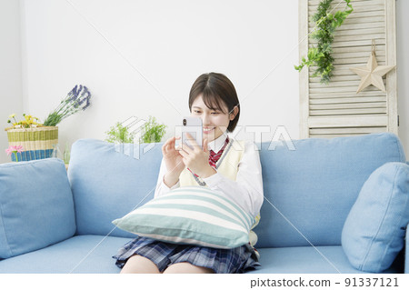 高中女生在客廳裡使用智能手機 91337121