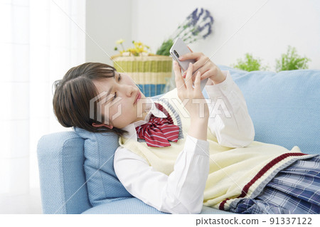 High school girl using a smartphone in the living room 91337122