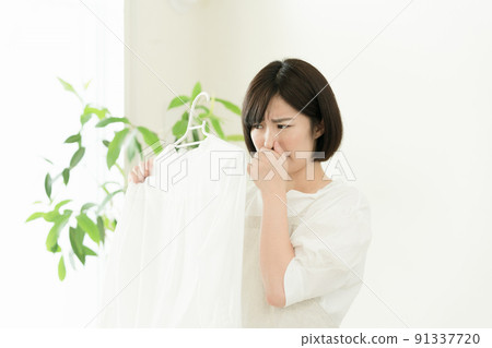 A woman who smells laundry 91337720