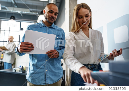 Two employees using new modern printer in office Two employees using new modern printer in office 91338503