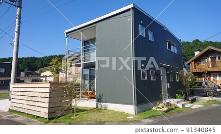 A stylish and modern mansion with a beautiful and cool outer wall of moss green aluminum spandrel that shines in the blue sky 91340845