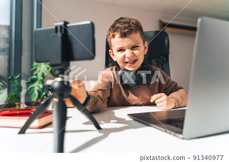 Boy is studying online at laptop 91340977