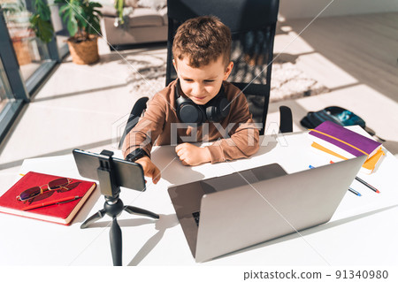 Boy is studying online at laptop Boy is studying online at laptop 91340980