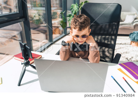 Schoolboy watches online video lessons on laptop. Studying during an epidemic Schoolboy watches online video lessons on laptop. Studying during an epidemic 91340984
