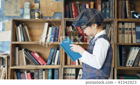 A boy reading a book in the library 91342023