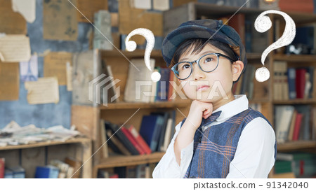 A boy thinking in front of a bookshelf A boy thinking in front of a bookshelf 91342040