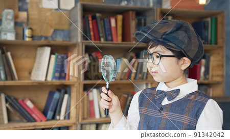Boy with magnifying glass 91342042