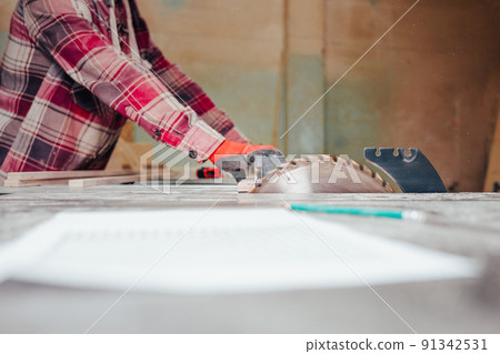 Carpenter cuts plywood on a circular saw. Carpenter cuts plywood on a circular saw. 91342531
