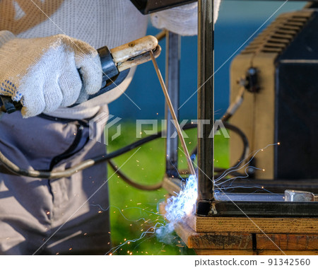 Welder's hands weld metal pipes. Welder's hands weld metal pipes. 91342560
