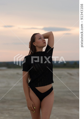Sexual woman in black outfit on beach 91343108