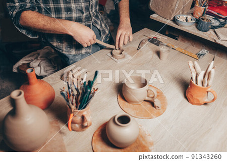 Process of creating a clay cup in pottery workshop. 91343260