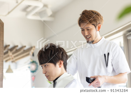 A man who has a haircut at a beauty salon A man who has a haircut at a beauty salon 91343284