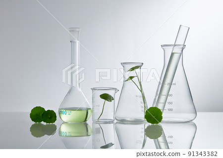 Product research and production of centella asiatica in a laboratory with medical devices on a white background. Blank label bottles for design 91343382