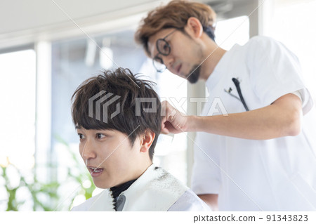 A man who has a haircut at a beauty salon A man who has a haircut at a beauty salon 91343823