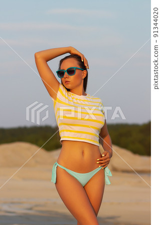 Sexy model in crop top and bikini panties on beach Sexy model in crop top and bikini panties on beach 91344020