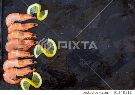 shrimp, lemon and sea salt on a dark black background. Copy space shrimp, lemon and sea salt on a dark black background. Copy space 91348118