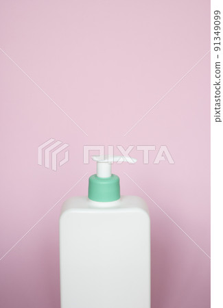 Large white cosmetic plastic bottle with pump dispenser pump and green cap on pink background. Liquid container for gel, lotion, cream, shampoo, bath foam. Large white cosmetic plastic bottle with pump dispenser pump and green cap on pink background. Liquid container for gel, lotion, cream, shampoo, bath foam. 91349099