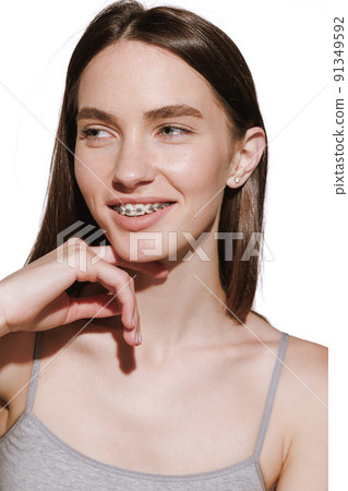 Portrait of smiling girl in braces isolated over white background. Perfect smile with dental teeth care 91349592
