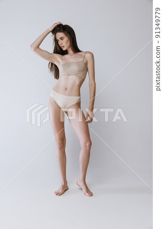 Health, slim and body of a woman in underwear isolated on a white  background in a studio. Wellness, beauty and stomach of a fitness girl with  a slimming shape, attradctive and in