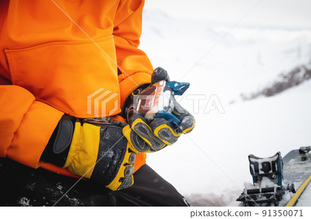 A skier wearing gloves switches ski bindings from ski touring mode to normal skiing mode. Close-up skitour preparation concept 91350071