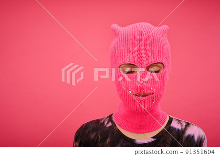 Portrait of yung girl in pink balaclava with closed mouth and eyes having no rights isolated on p Portrait of yung girl in pink balaclava with closed mouth and eyes having no rights isolated on p 91351604