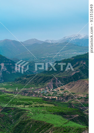 foggy alpine valley with villages and fields between mountain peaks in Dagestan 91351649