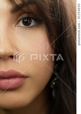 Half a beauty portrait with beautiful fashionable evening make-up, black jiggles on eyes and extremely long eyelashes. Pink lipstick on the lips. Cosmetology and spa facial skin care Half a beauty portrait with beautiful fashionable evening make-up, black jiggles on eyes and extremely long eyelashes. Pink lipstick on the lips. Cosmetology and spa facial skin care 91354650