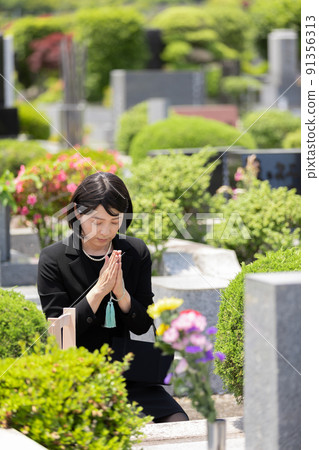 Middle woman visiting a grave 91356313