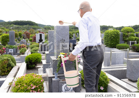 Senior man cleaning tombstones Senior man cleaning tombstones 91356978