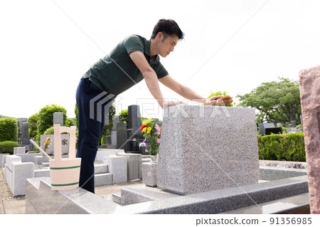 Man cleaning the grave 91356985