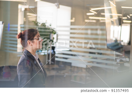 Business woman watching TV in conference room.  91357495