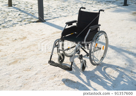 Empty wheelchair in the park in winter. Empty wheelchair in the park in winter. 91357600