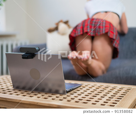 Faceless young woman dressed in schoolgirl costume for online sex. The web model is dancing twerk to the camera 91358082