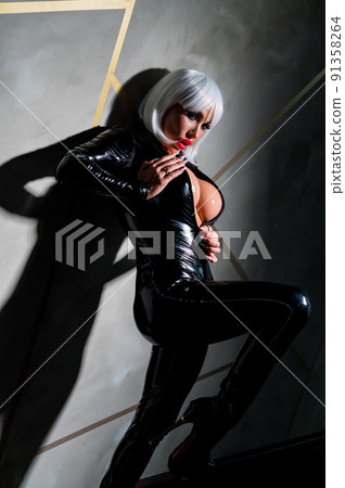 Sexy woman in a blonde wig and latex catsuit. Role-playing games 91358264