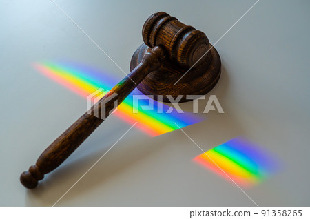 Judicial gavel on a table with a rainbow light prism.  91358265