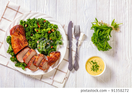 Roast Pork Tenderloin with kale salad on plate 91358272