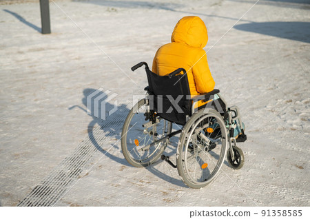 Homeless woman sitting in wheelchair in winter. Homeless woman sitting in wheelchair in winter. 91358585