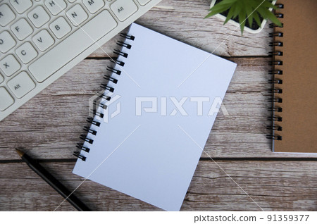 Top view of simple office desk with computer keyboard, pen and blank notepad. Top view of simple office desk with computer keyboard, pen and blank notepad. 91359377