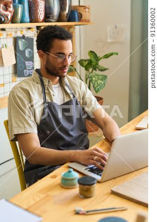 Young creative man in workwear concentrating on work over new project 91360002