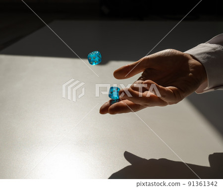 Woman throws a pair of blue transparent dice. Woman throws a pair of blue transparent dice. 91361342