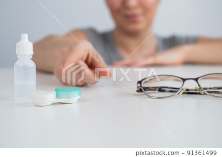 Caucasian woman prefers contact lenses to glasses.  91361499