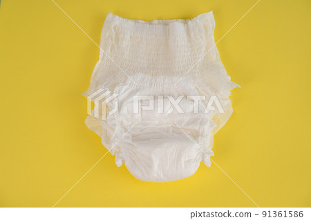 Adult diaper on a yellow background. Incontinence problems. 91361586