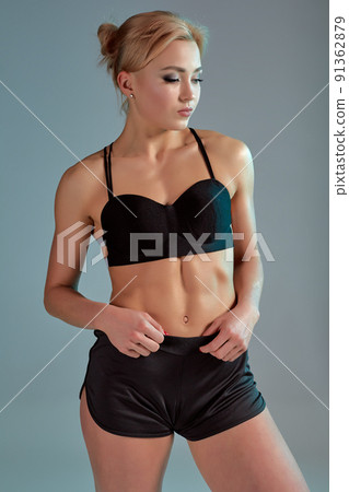 Fitness woman in black tank top and shorts, studio shot. 91362879