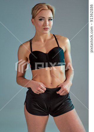 Fitness woman in black tank top and shorts, studio shot. 91362886