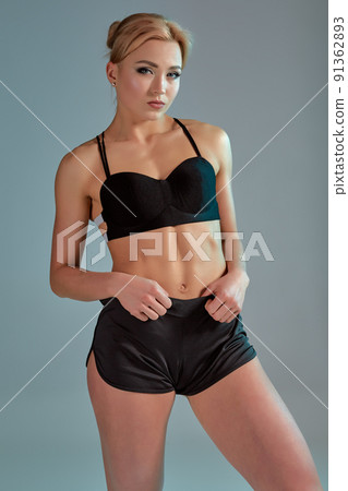 Fitness woman in black tank top and shorts, studio shot. 91362893