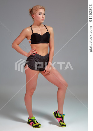 Fitness woman in black tank top and shorts, studio shot. 91362898