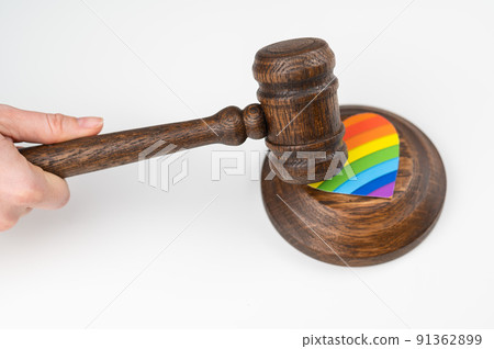 The judge hits a heart with a rainbow flag with a gavel. 91362899