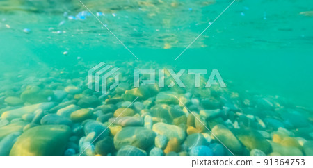 Sea pebble bottom in turquoise slightly turbid shallow water. Underwater photography. Blurred image Sea pebble bottom in turquoise slightly turbid shallow water. Underwater photography. Blurred image 91364753