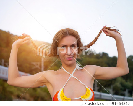 Smiling girl in a bikini holding her pigtails Stock Photo